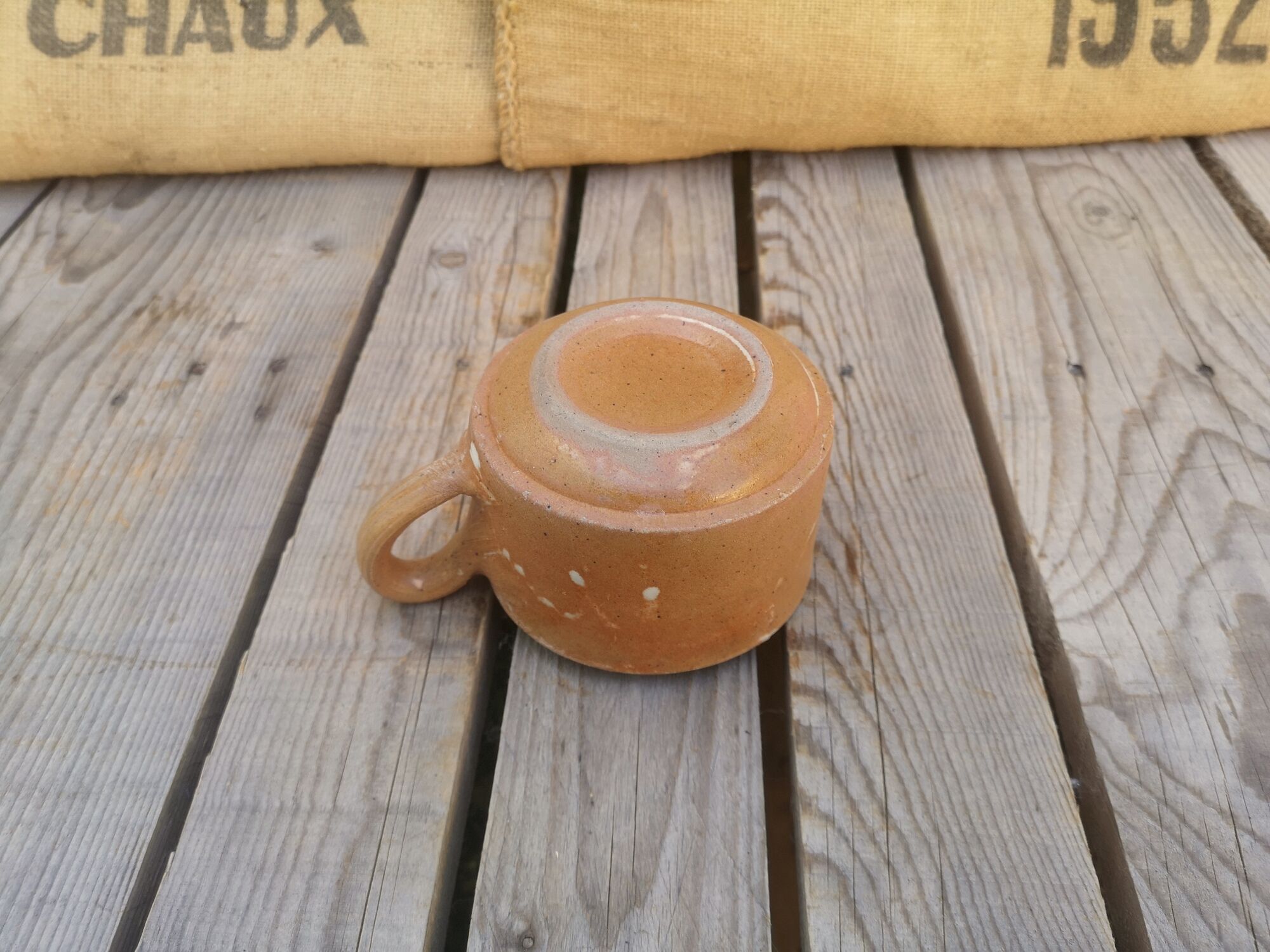 Brown sandstone cup with white spots