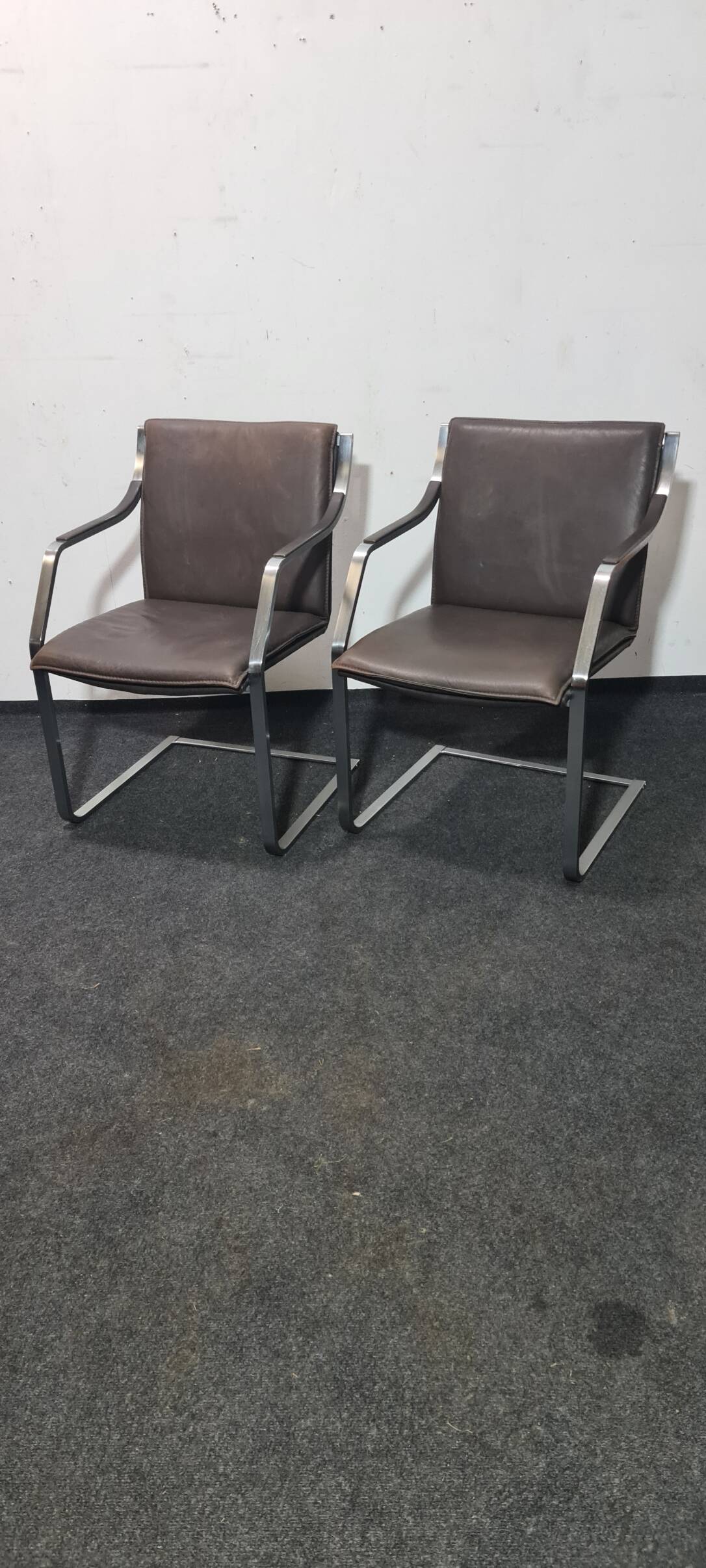 One of two vintage Leather and metal arm chairs.