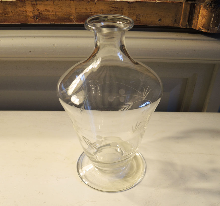 Old carafe in engraved glass vegetal decoration