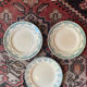3 flat plates in ironstone with a floral green border.