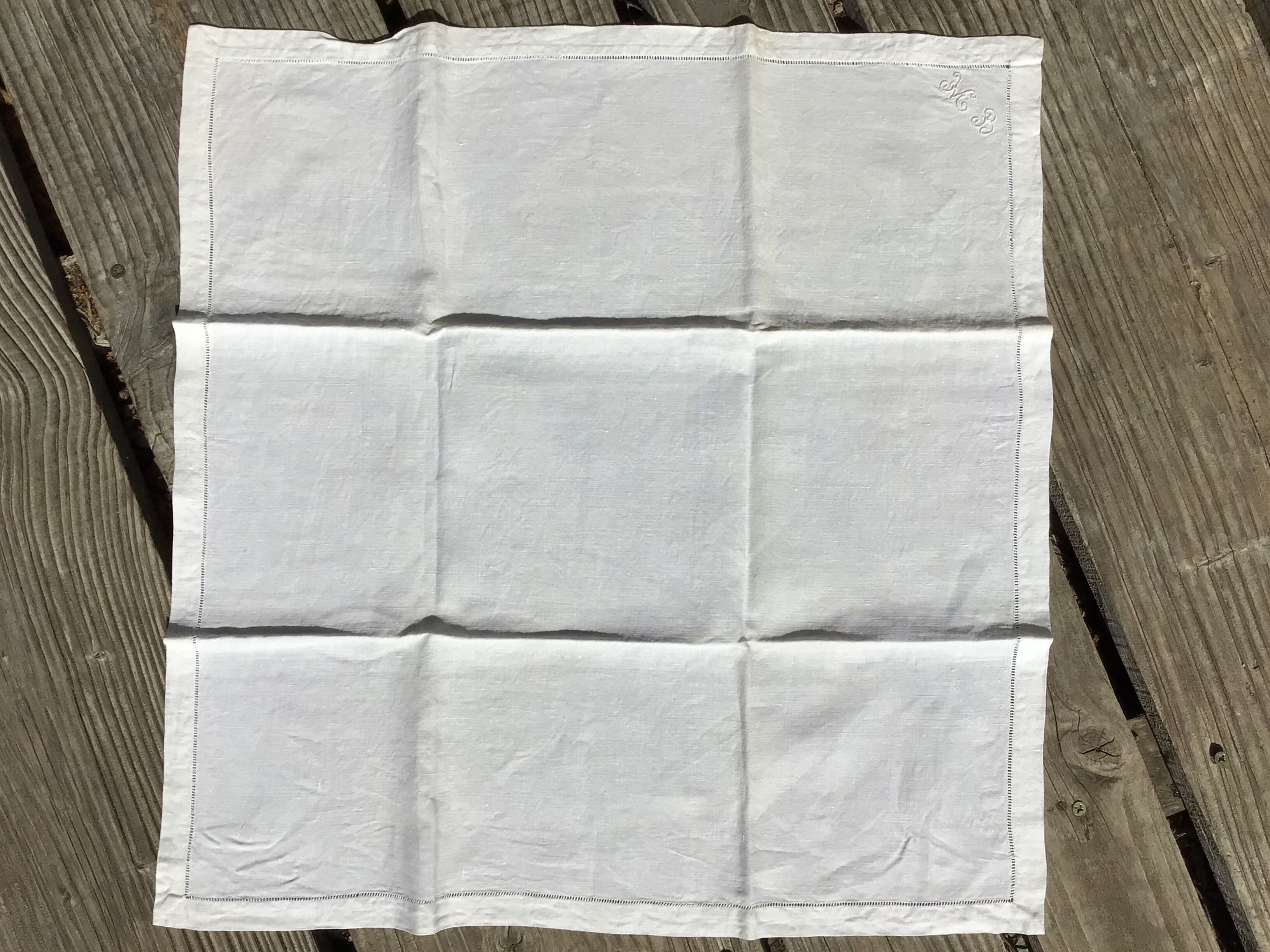 6 square linen napkins with hand-embroidered initials in the corner.