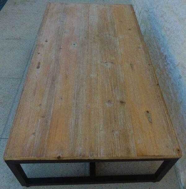 Table basse de style industrielle à plateau de bois supporté par un piètement métallique-
