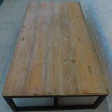 Table basse de style industrielle à plateau de bois supporté par un piètement métallique-