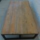 Industrial style coffee table with wooden top supported by a metal base -