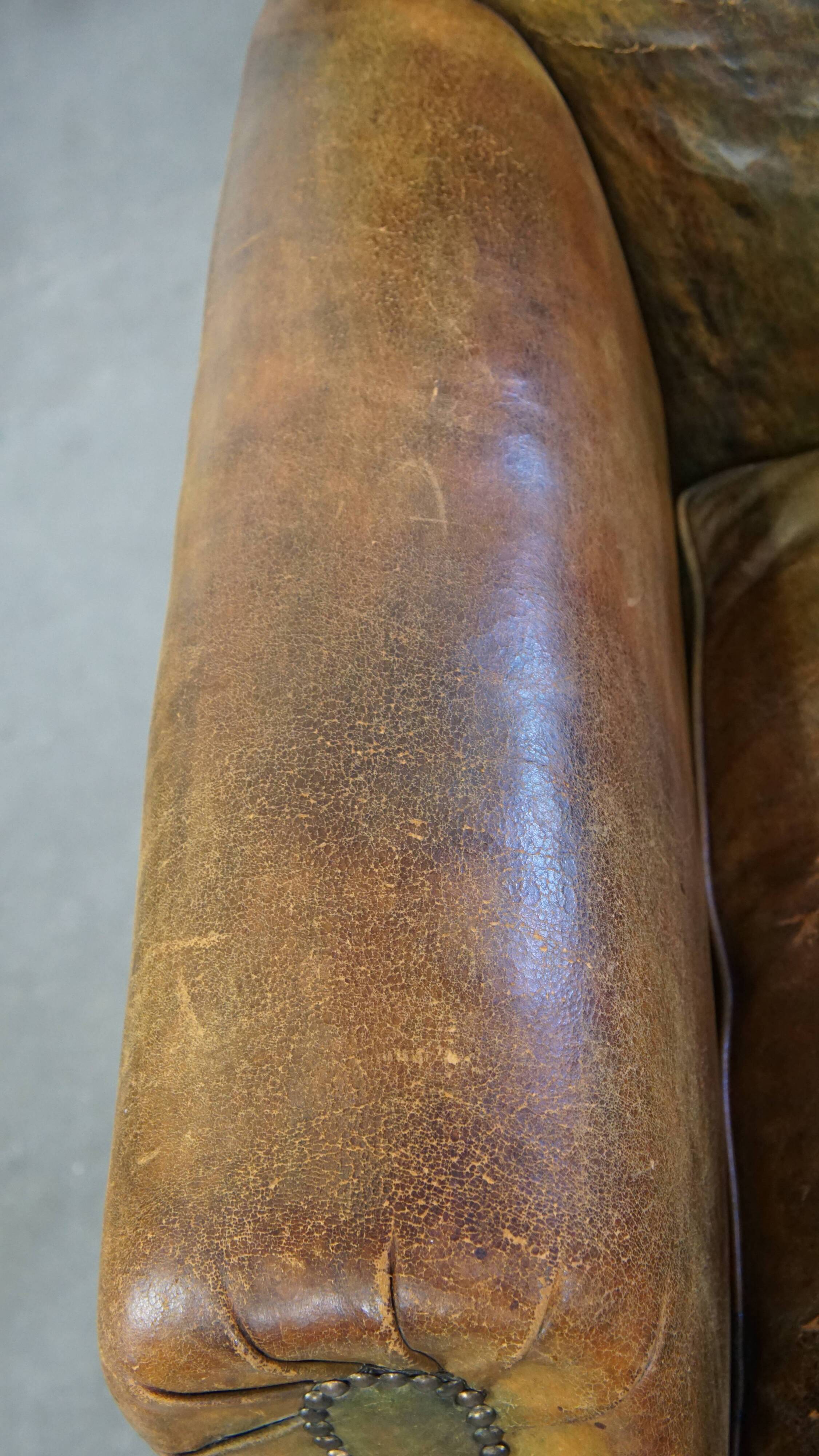 Green antique English cowhide leather armchair on wheels