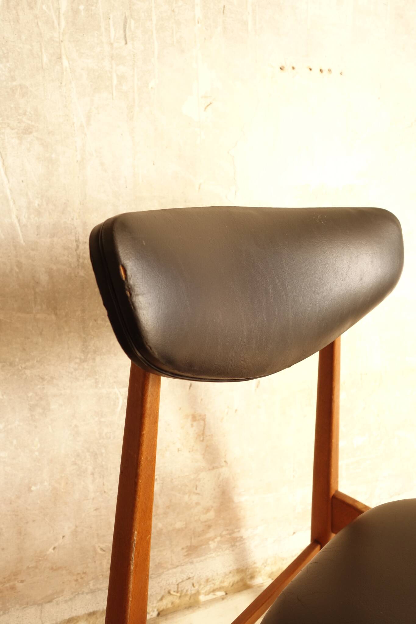 Pair of modernist Scandinavian chairs in teak and black faux leather.