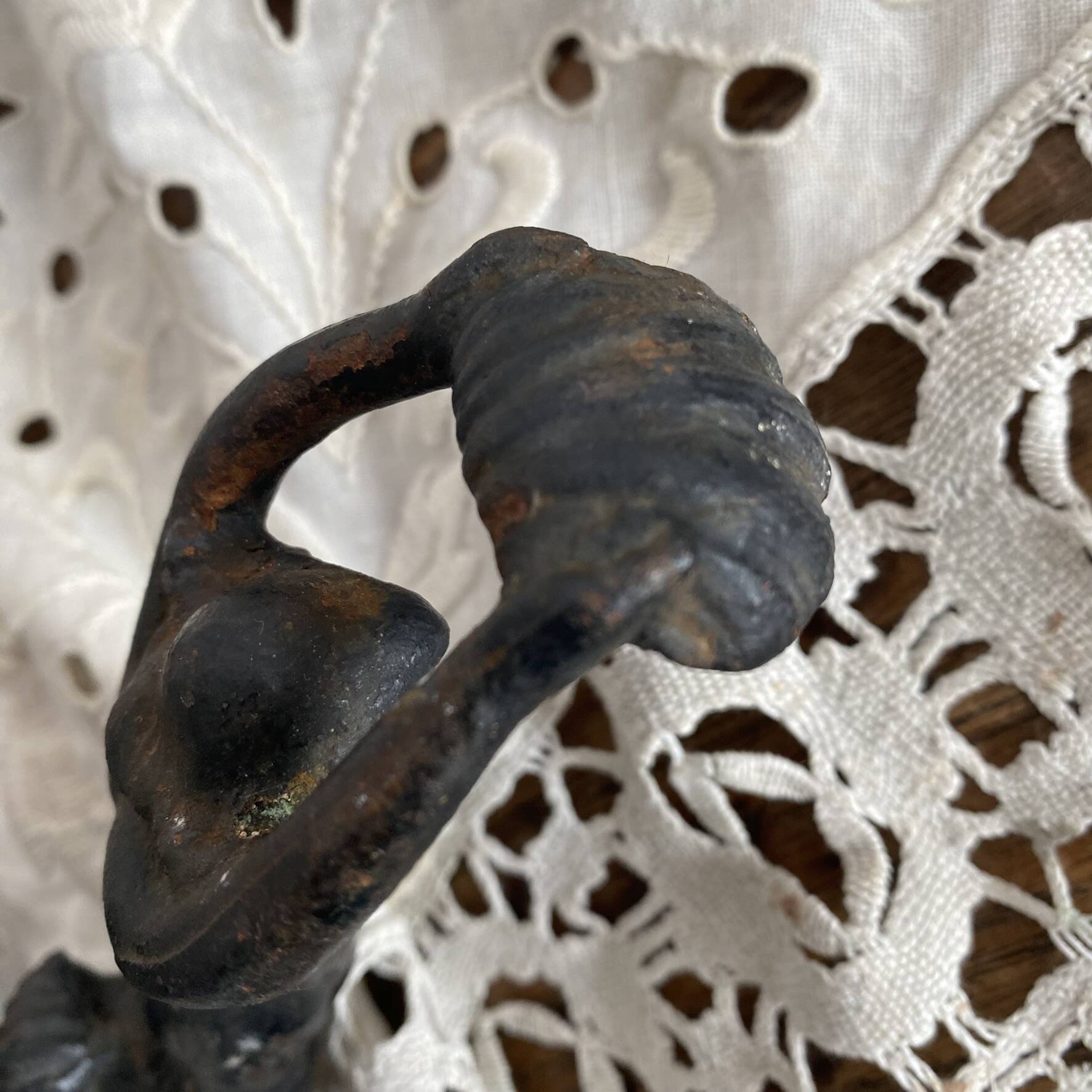 Antique cast iron coat hook with swimmer and shell basin.