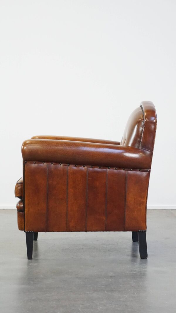 Fauteuil en cuir de mouton avec clous décoratifs et passepoil noir
