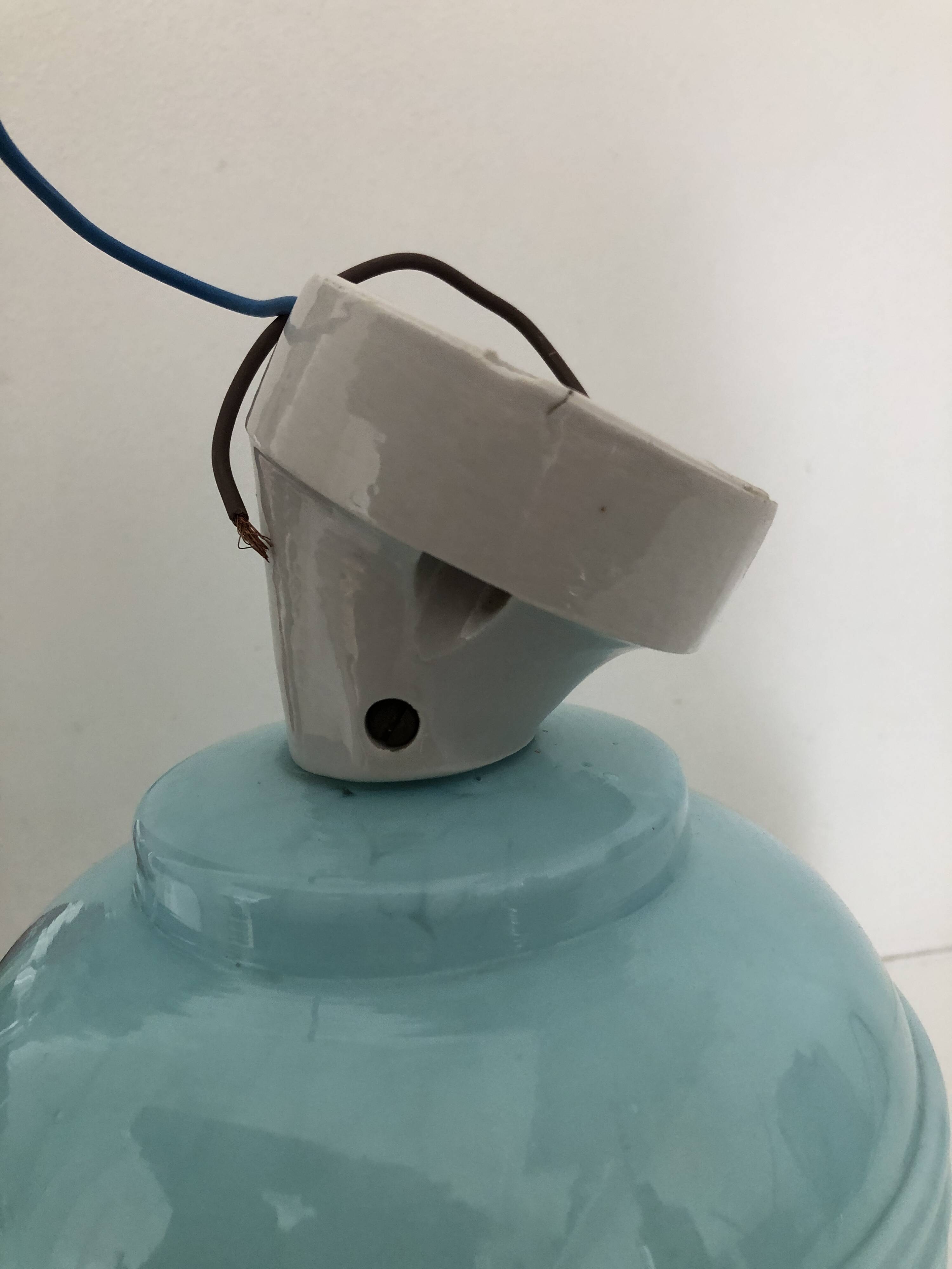 Wall light in ceramic with a light blue glass globe.