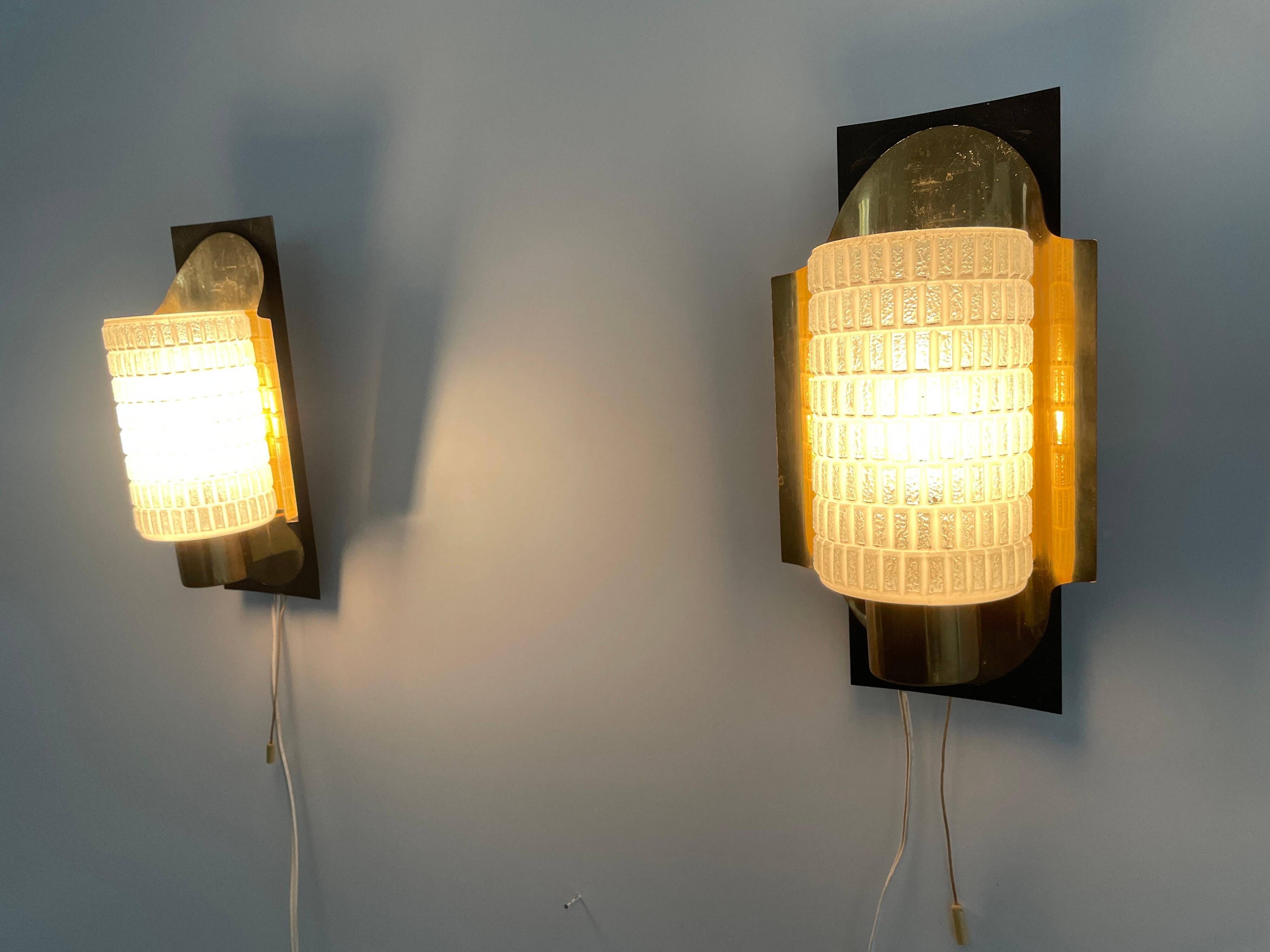 Mid-century pair of wall sconces in textured glass and brass, 1950s, Germany.