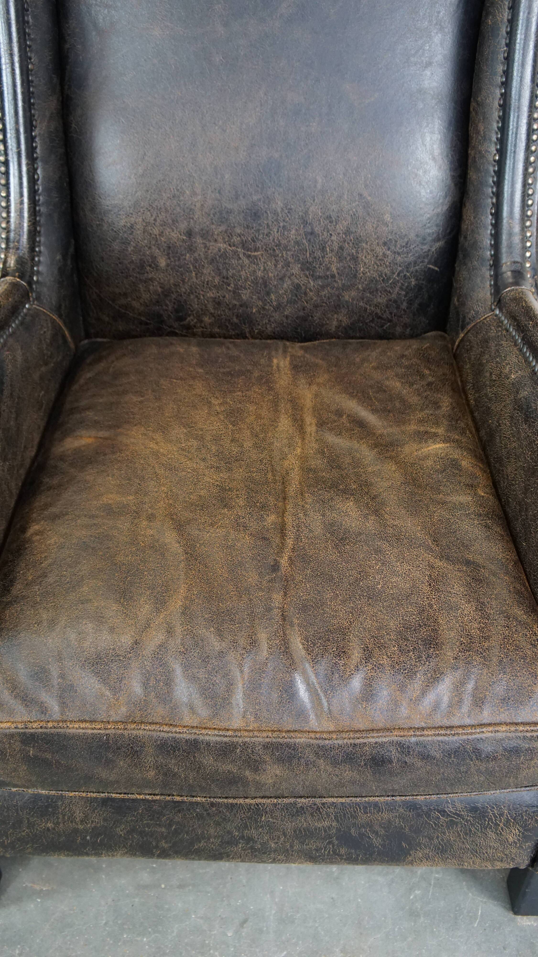 Set of 2 black cow leather armchairs finished with decorative nails, industrial style