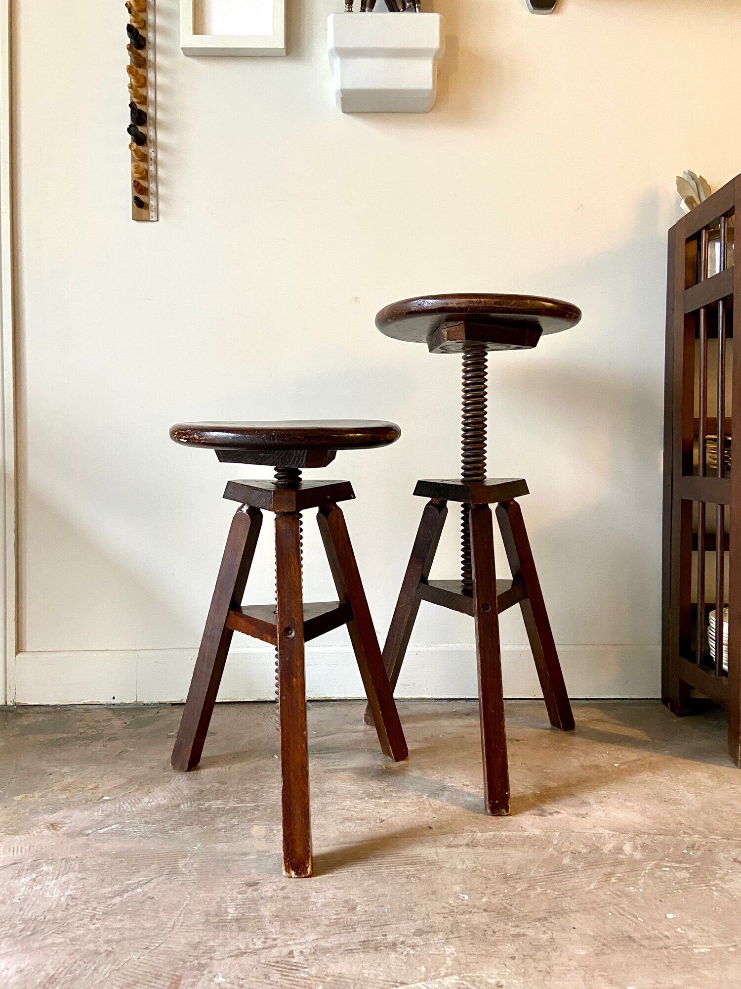 2 tripod stools with dark wood screws