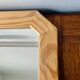 Octagonal mirror in light wood with grooves.