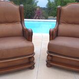 Pair of aged leather armchairs with seat and firm backrest with cherry wood frame