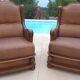 Pair of aged leather armchairs with seat and firm backrest with cherry wood frame