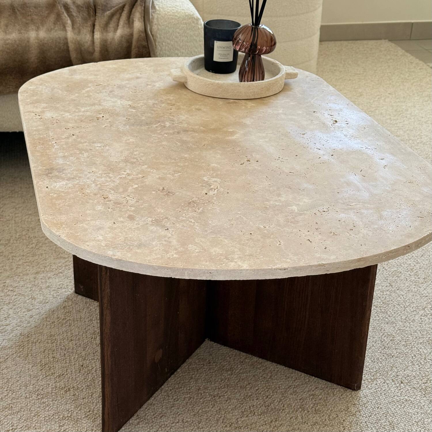 Oval coffee table in travertine and dark oak.