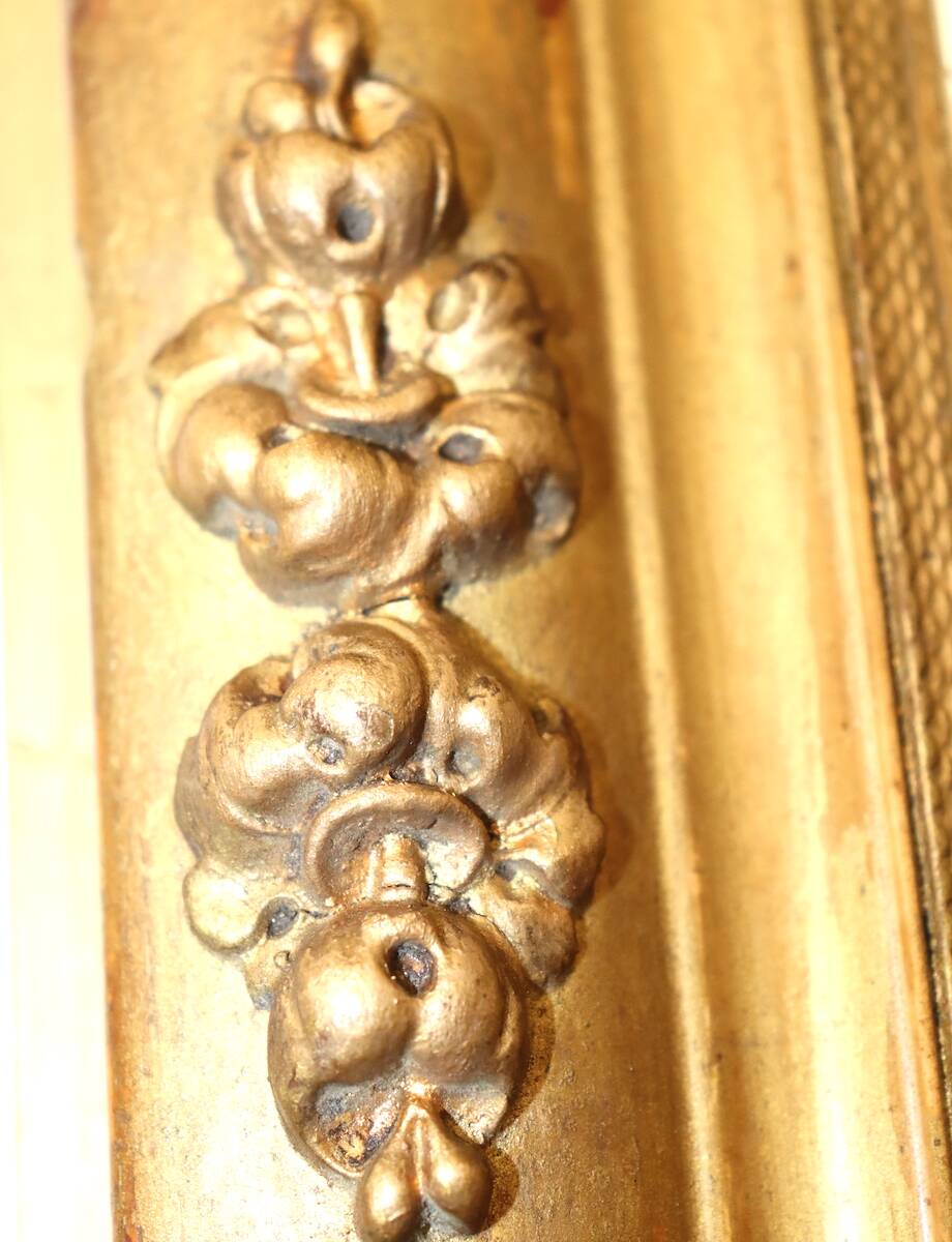 Rectangular mirror in gilded wood with relief decoration of flowers.