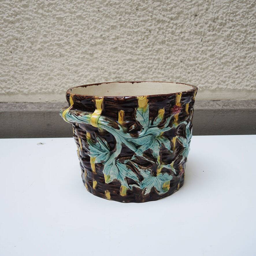 Old earthenware pot with ivy decoration.