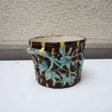 Old earthenware pot with ivy decoration.