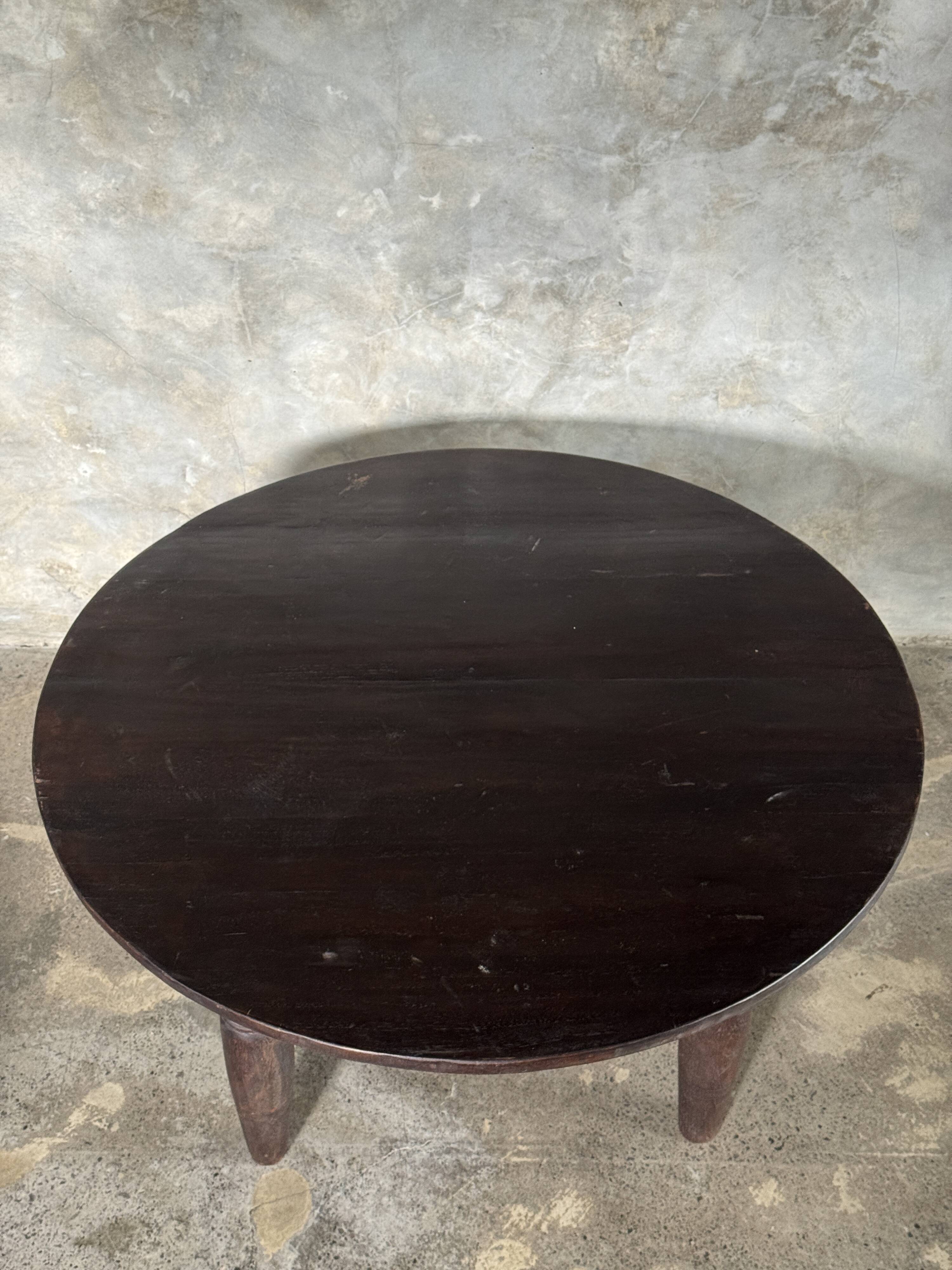 Antique round coffee table in Indonesian teak with turned legs.