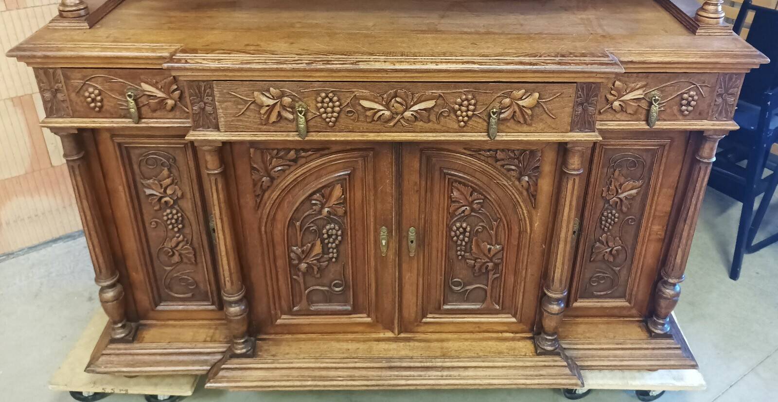 Art Nouveau buffet in carved oak with grapevine cluster decoration.