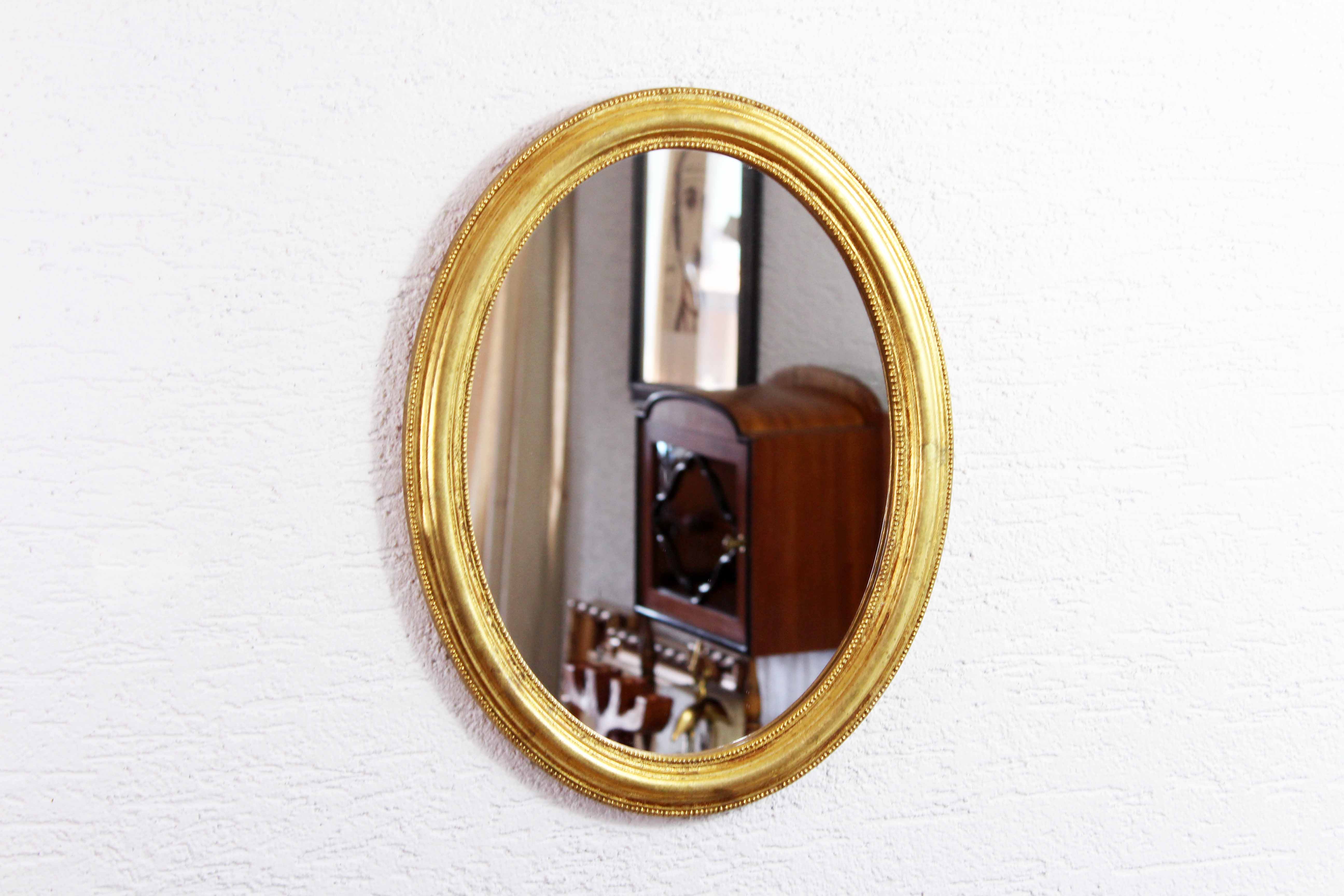 Golden oval mirror with leaf