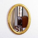 Golden oval mirror with leaf