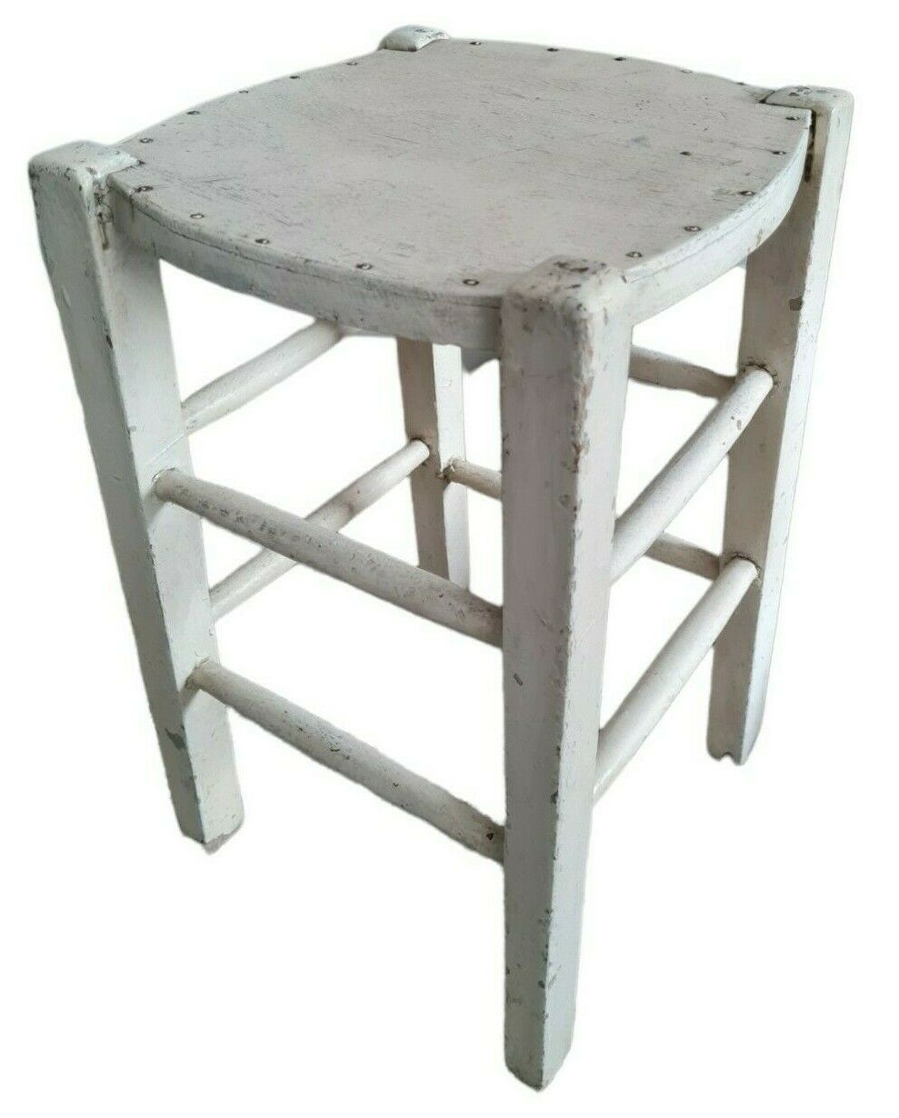 Vintage wooden stool with white peeling paint
