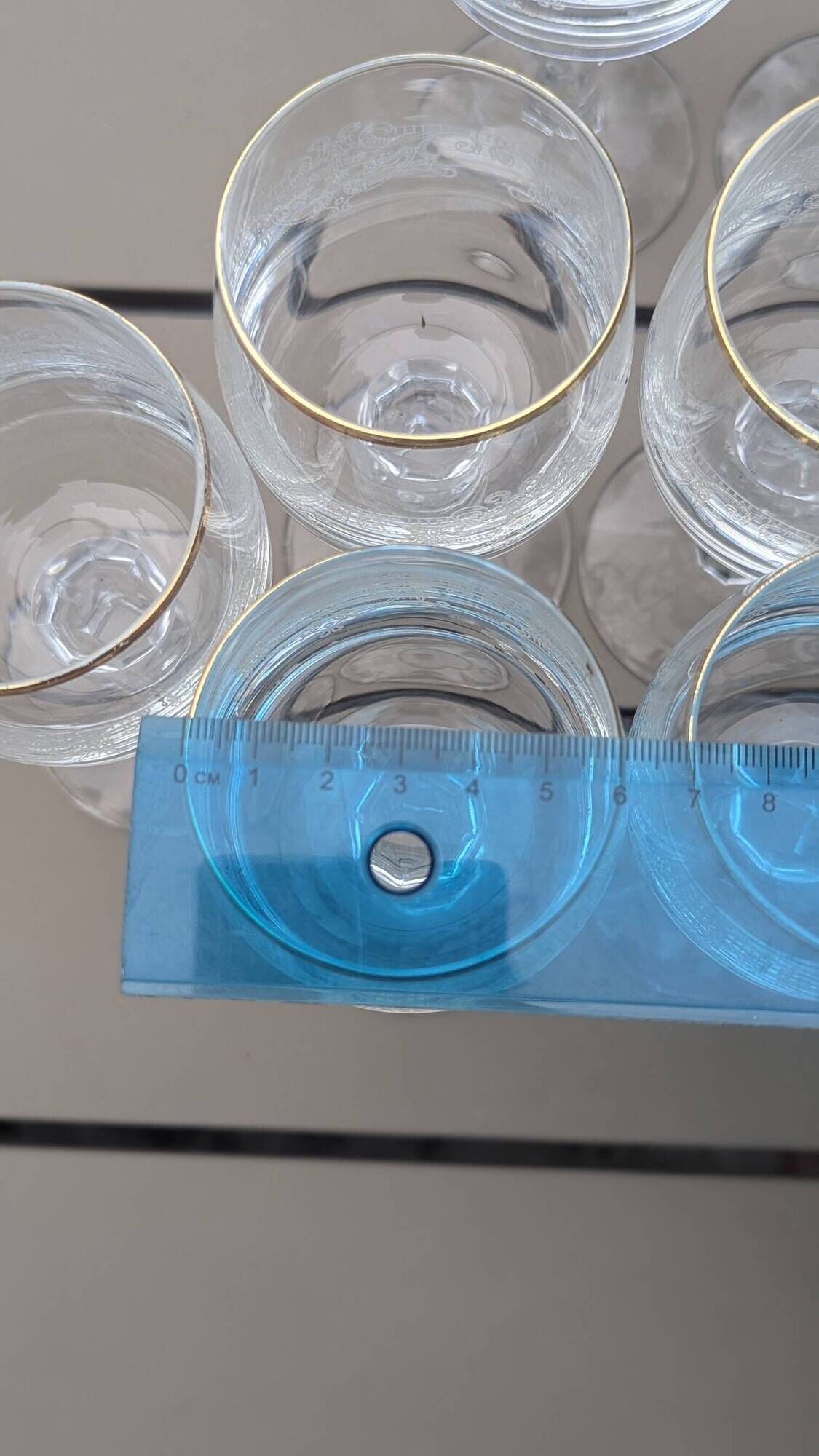 Set of 15 engraved crystal glasses with a gold rim.