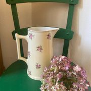 Old flowery and gilded pitcher.