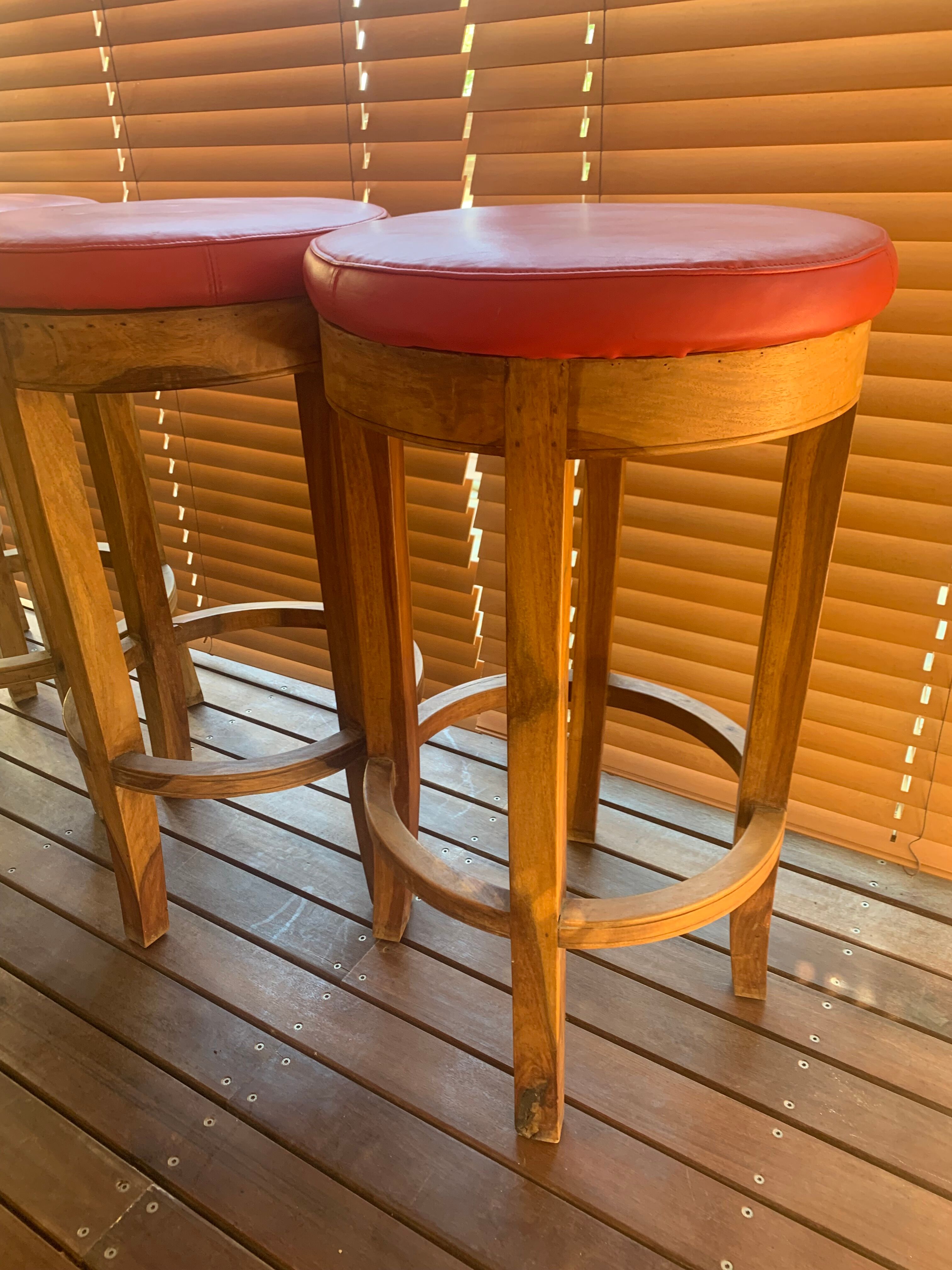 Set of 4 bar stools in solid exotic wood and red leather.
