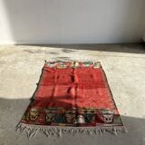 Small wool rug, predominantly red with geometric patterns