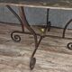 Table en fer forgé à piétement sculptural, ornée de volutes