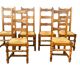 Set of 6 solid wood chairs with straw seats.