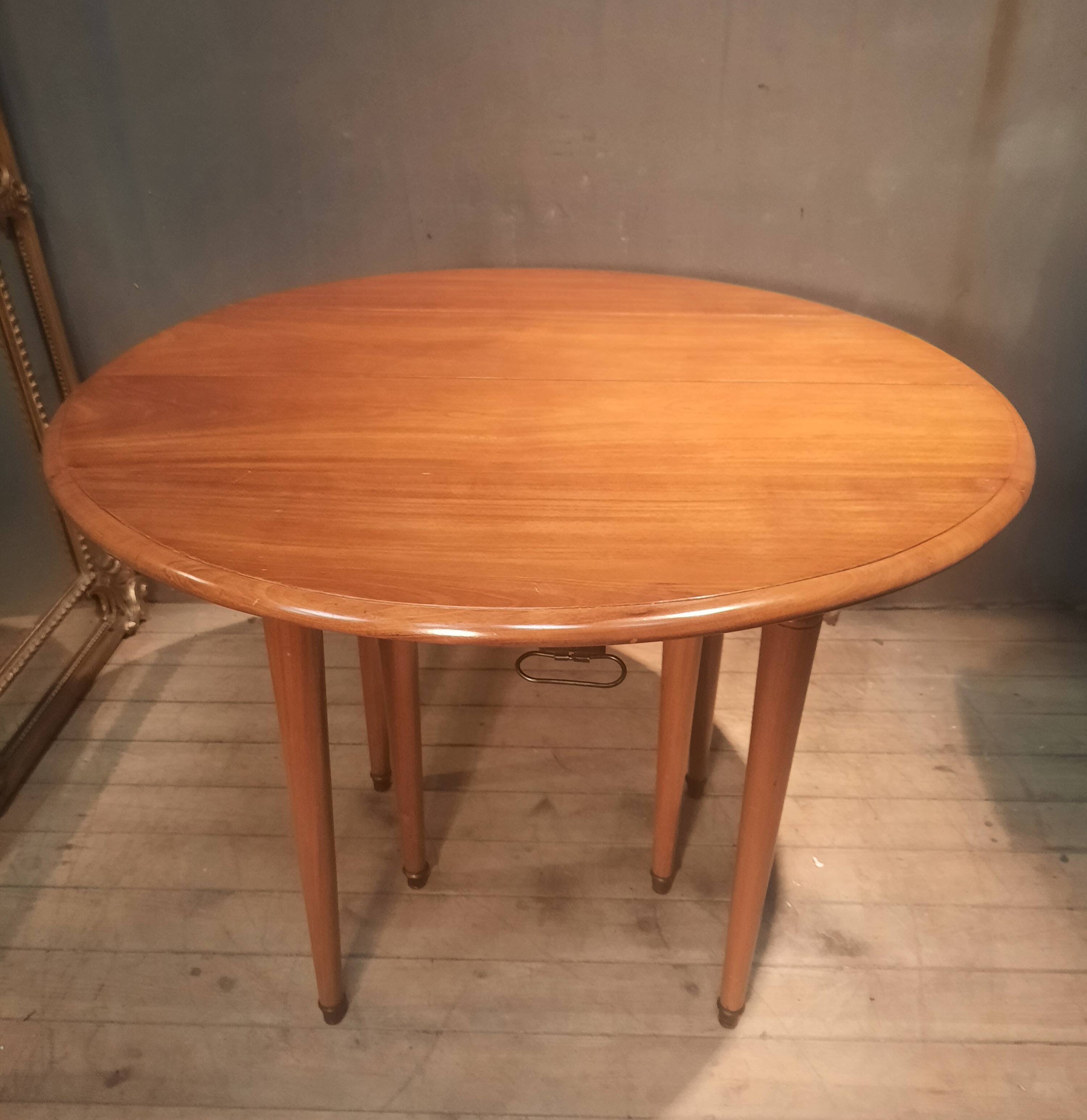 Drop-leaf table with 6 legs and 3 extensions.