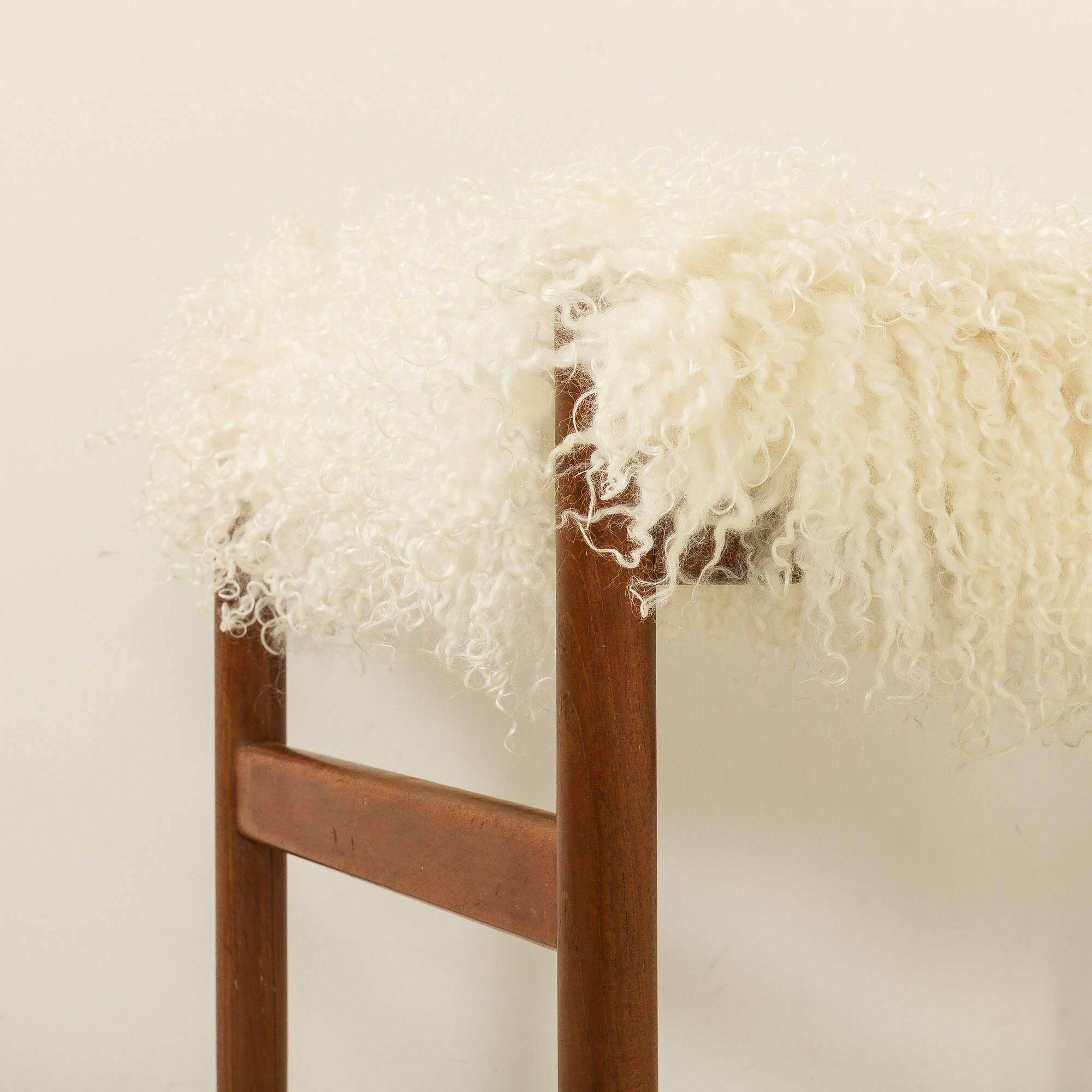 Pouf en teck danois des années 60 recouvert de peau de mouton à poils longs.