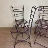 Series of four designer cast iron chairs with reversed backs and very beautiful x-legs