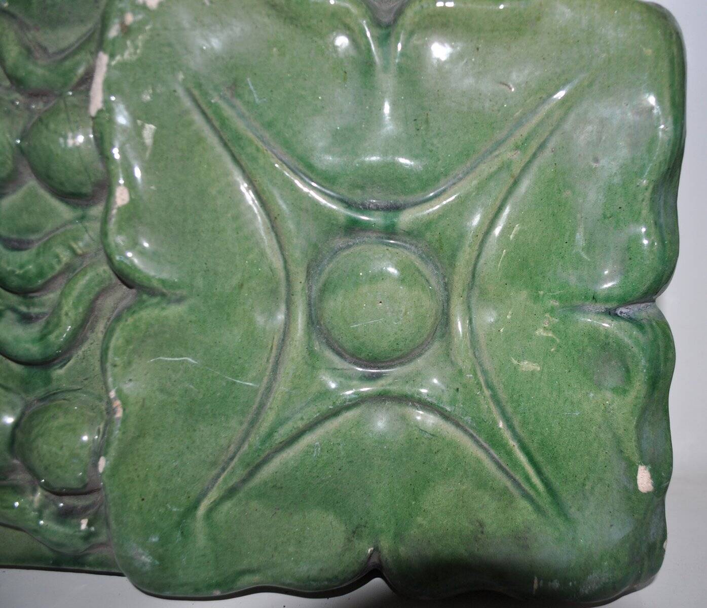 Green enamelled ceramic stove tile — finely sculpted Hungarian pattern from the late 19th century.