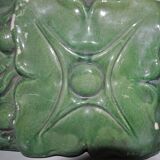 Green enamelled ceramic stove tile — finely sculpted Hungarian pattern from the late 19th century.