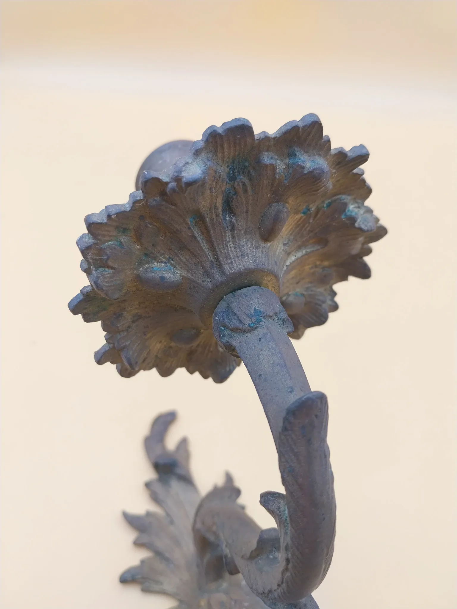 Pair of wall sconces in bronze candle holders with leaf medallion decoration.