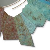 Contemporary mirror in oxidized bronze and brass with a deconstructed shape.