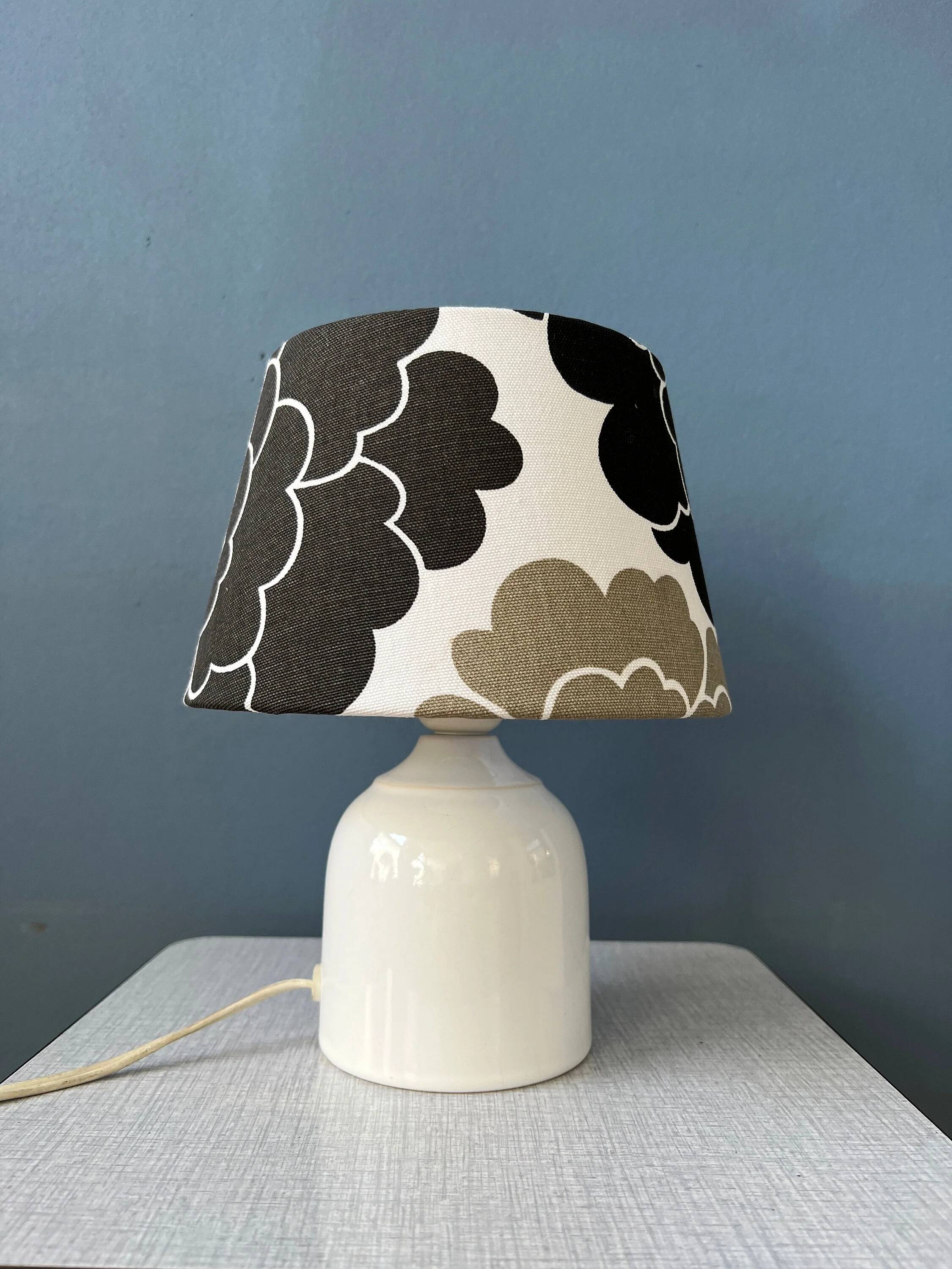 Small Space Age table lamp with a porcelain base and black and white flower shade.