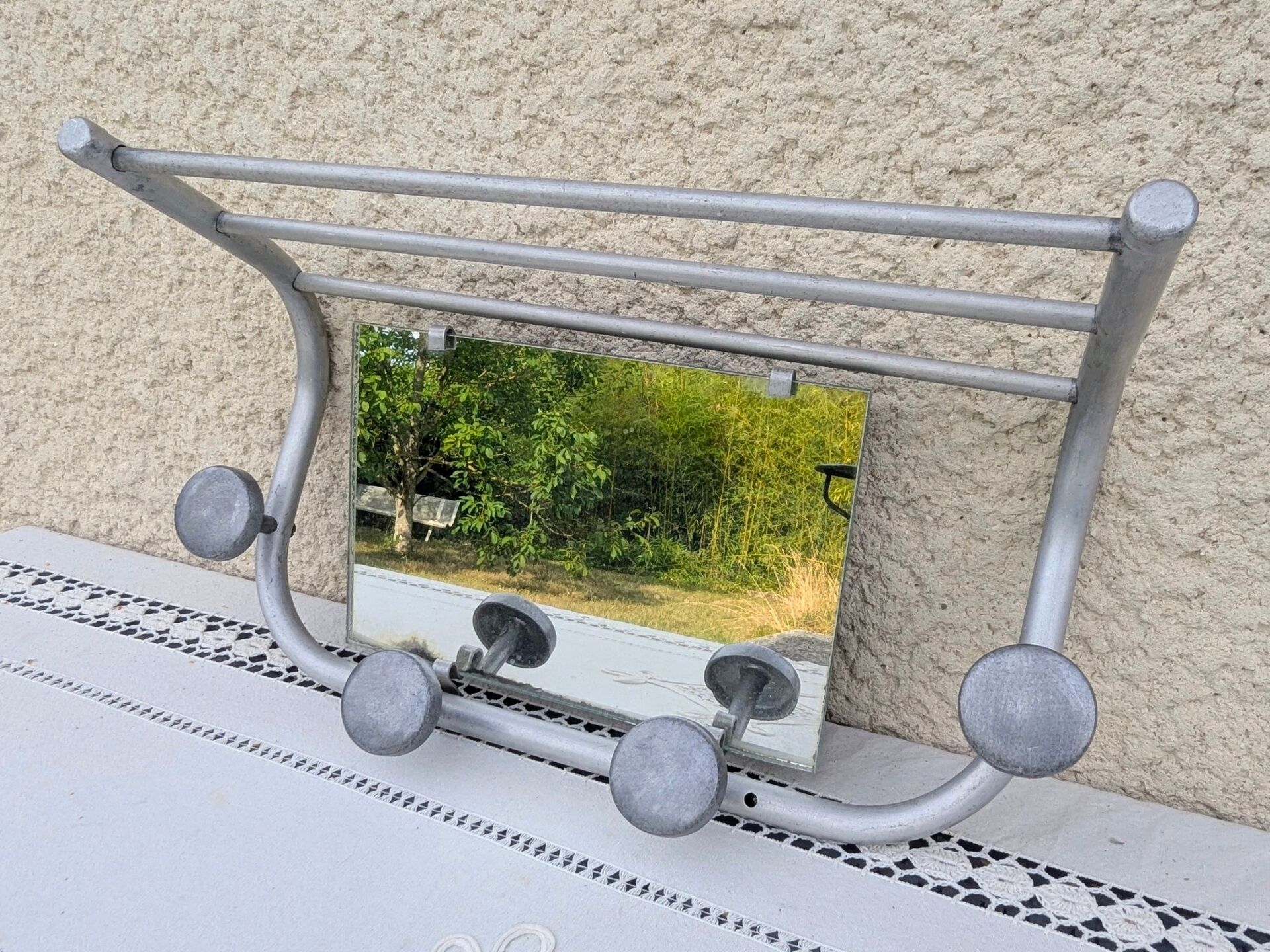 Vintage train style wall-mounted hat rack with angled mirror.