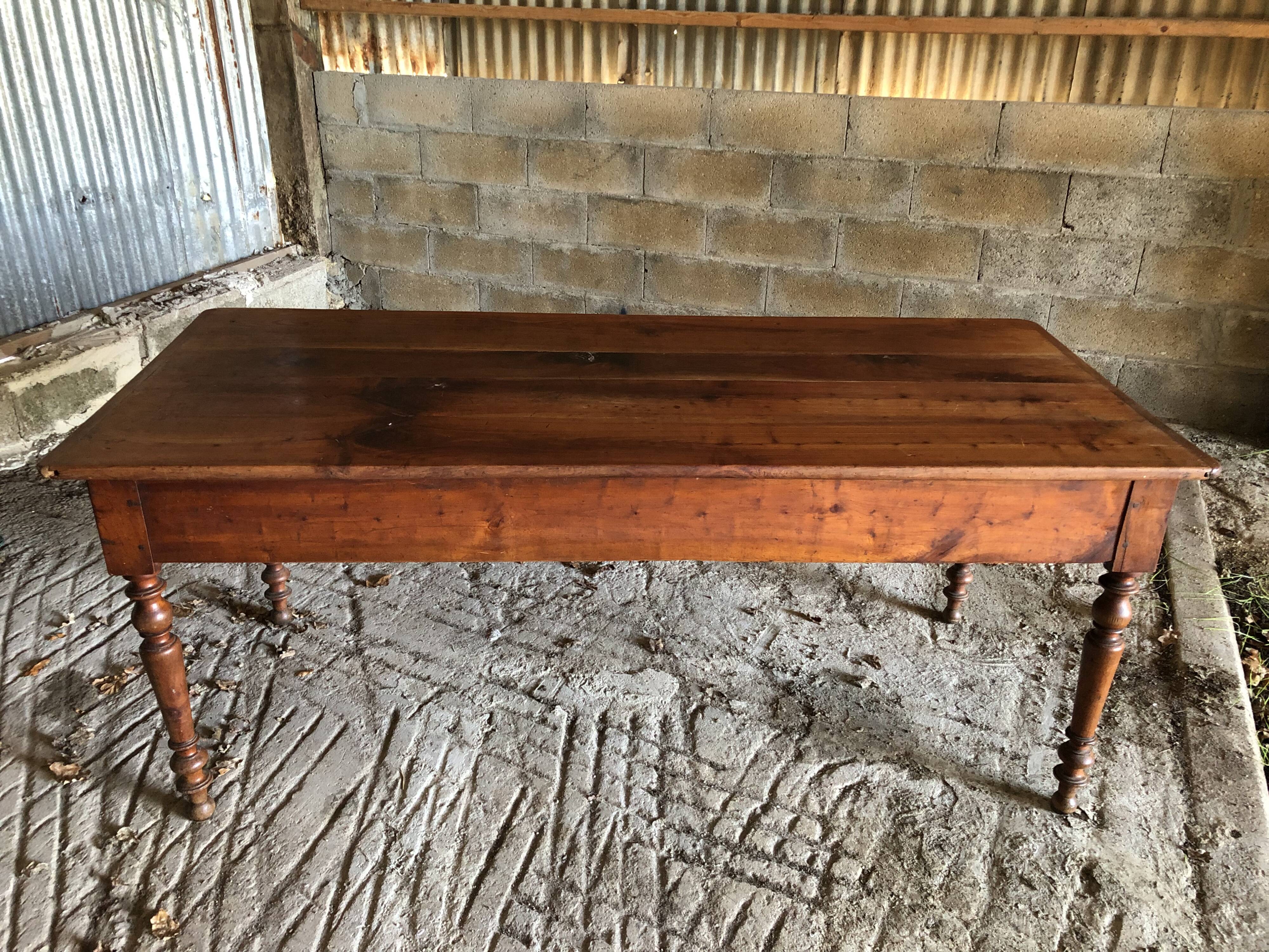 Antique Louis Philippe style farm table in solid cherry wood with turned base.