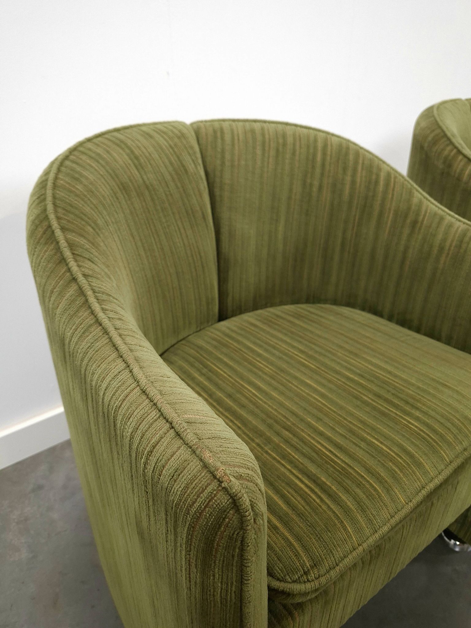 Chaises de cocktail vertes avec des roues chromées.