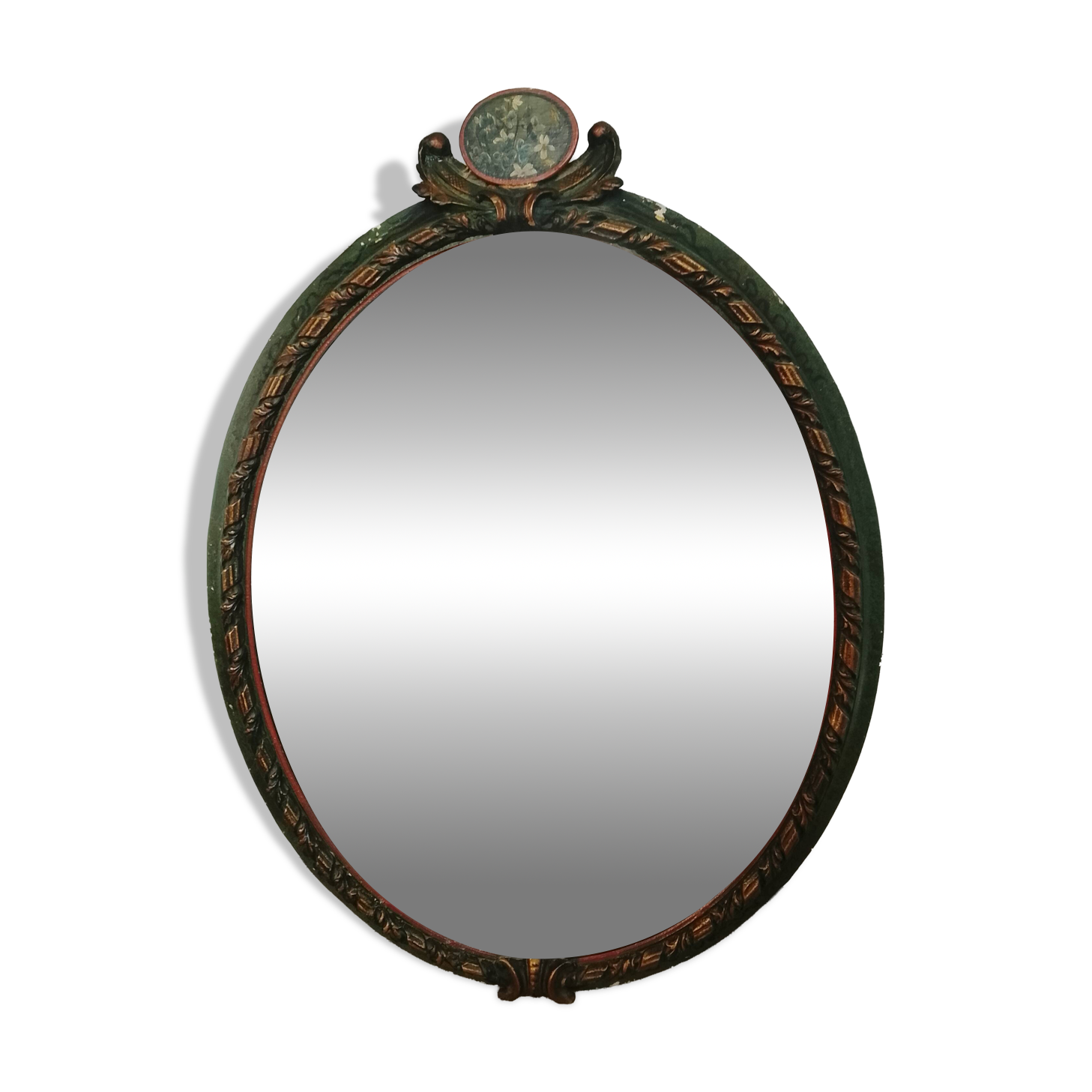 Antique oval mirror in a carved and painted frame with a floral panel.