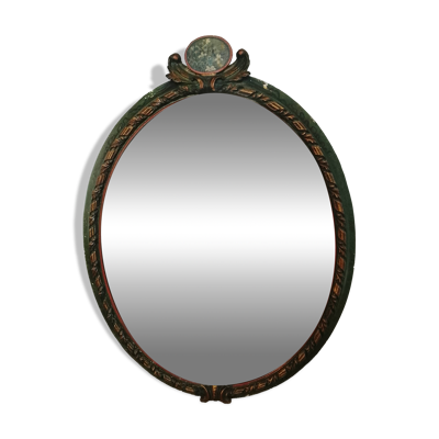 Miroir ovale ancien dans un cadre sculpté et peint avec un panneau floral