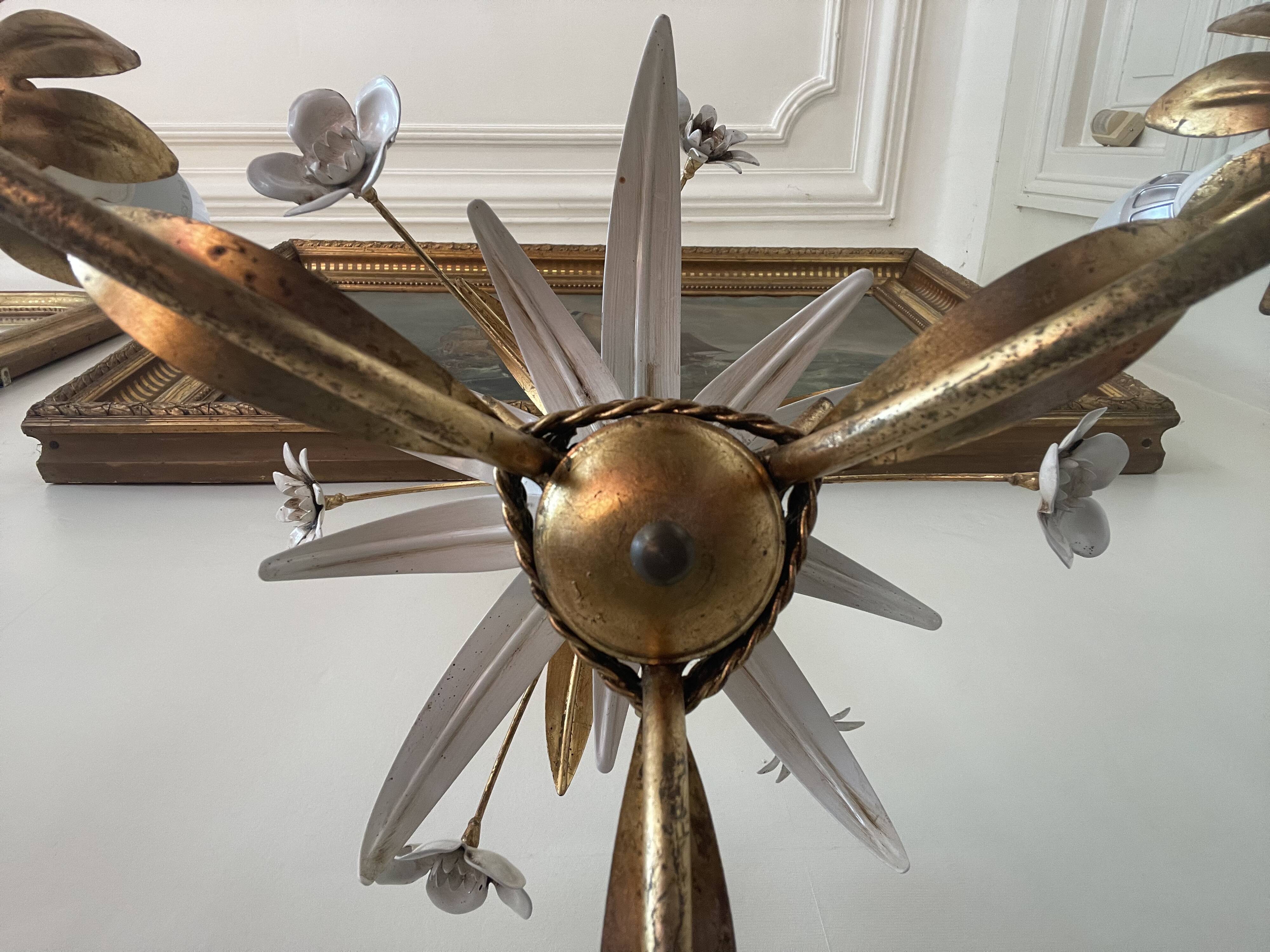 Golden metal chandelier decorated with flowers