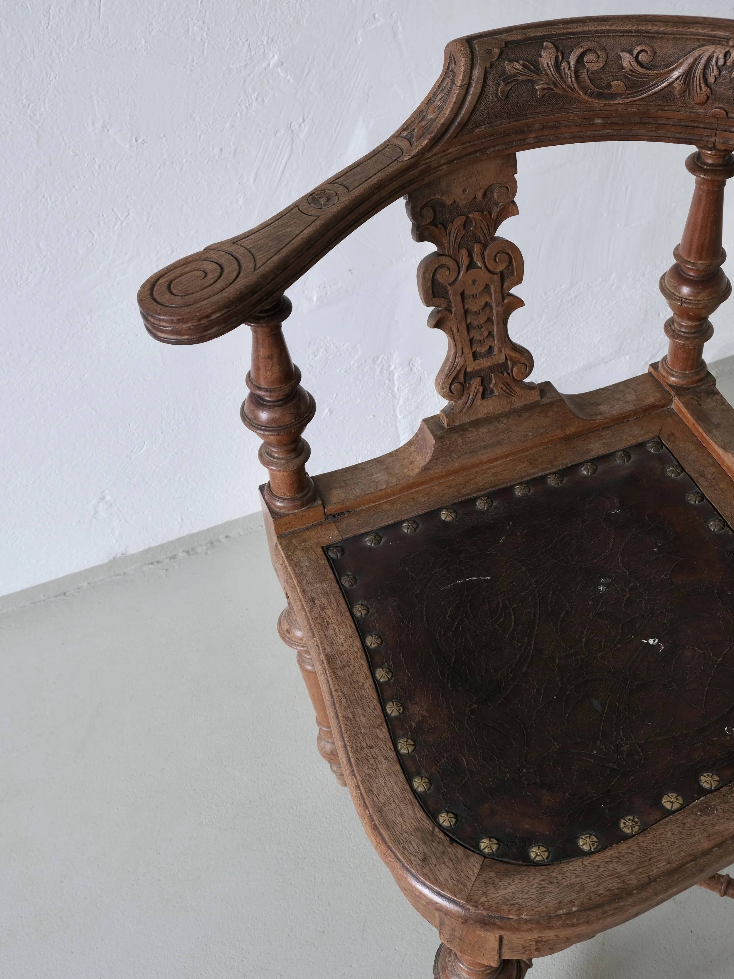 Fauteuil d'angle ancien sculpté avec assise en cuir