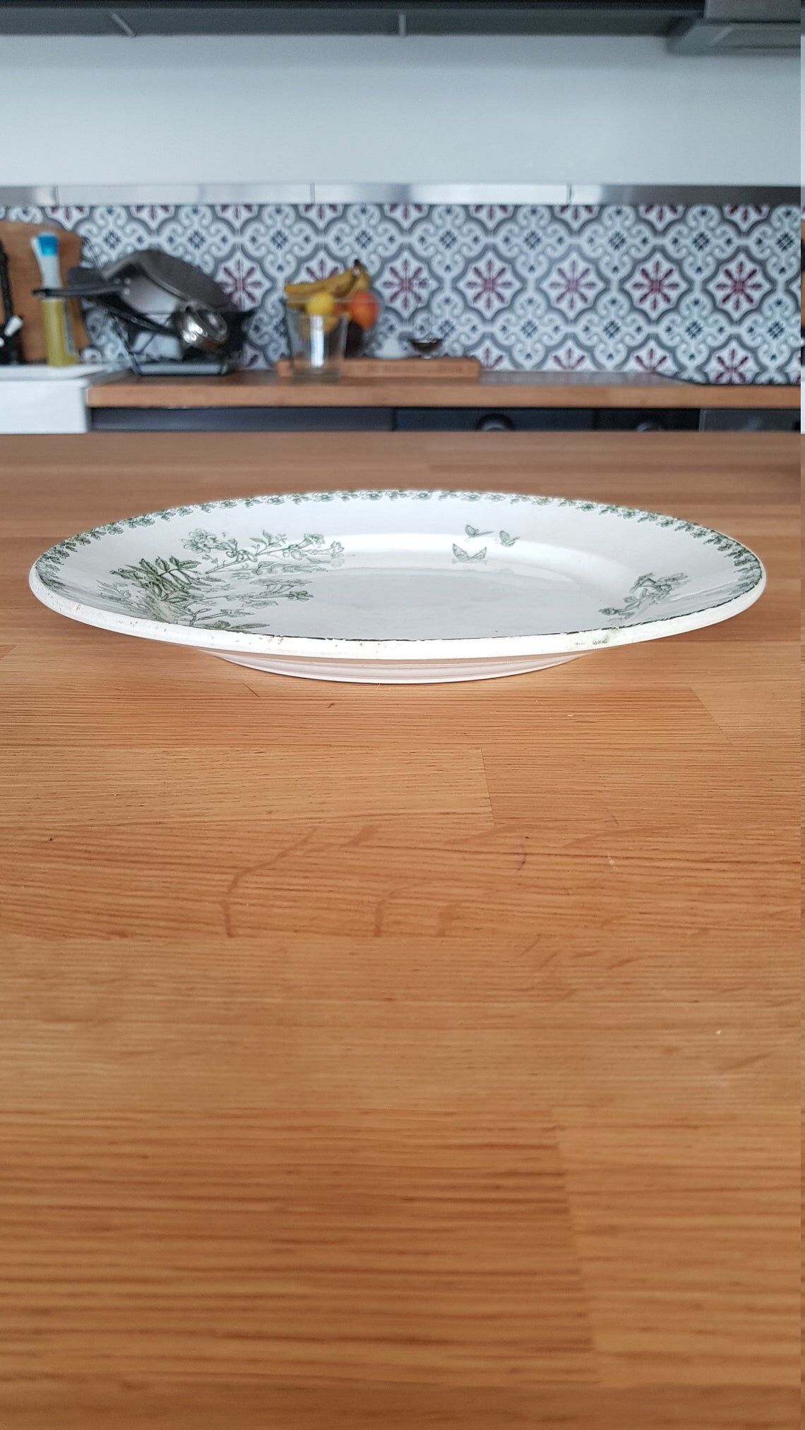 White and green ceramic dish decorated with flowers and butterflies